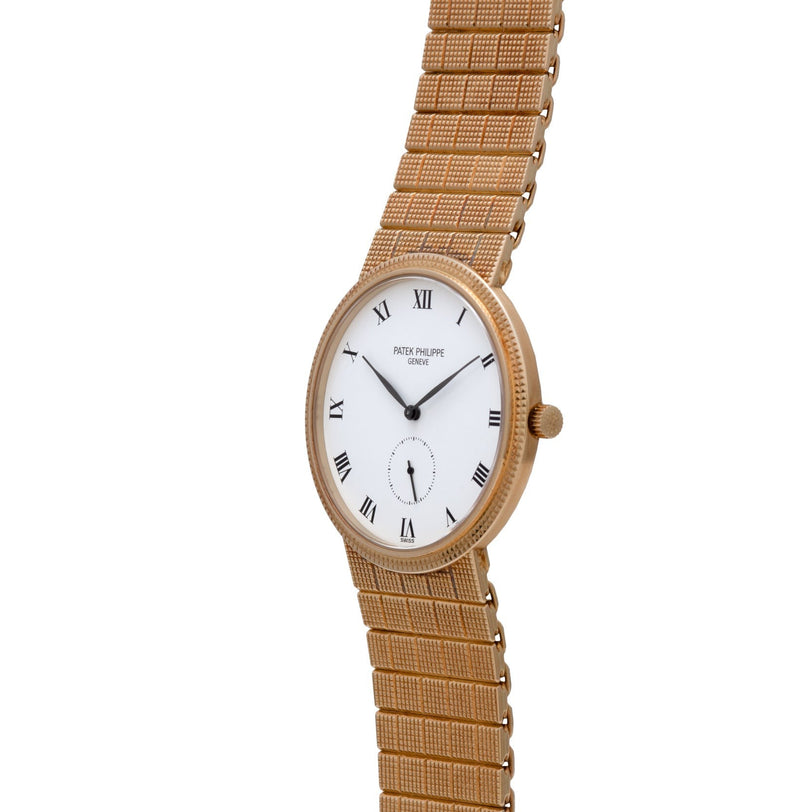 The Patek Philippe Calatrava features a gold case, white dial with Roman numerals, woven metal band, and displays the time 1:55.