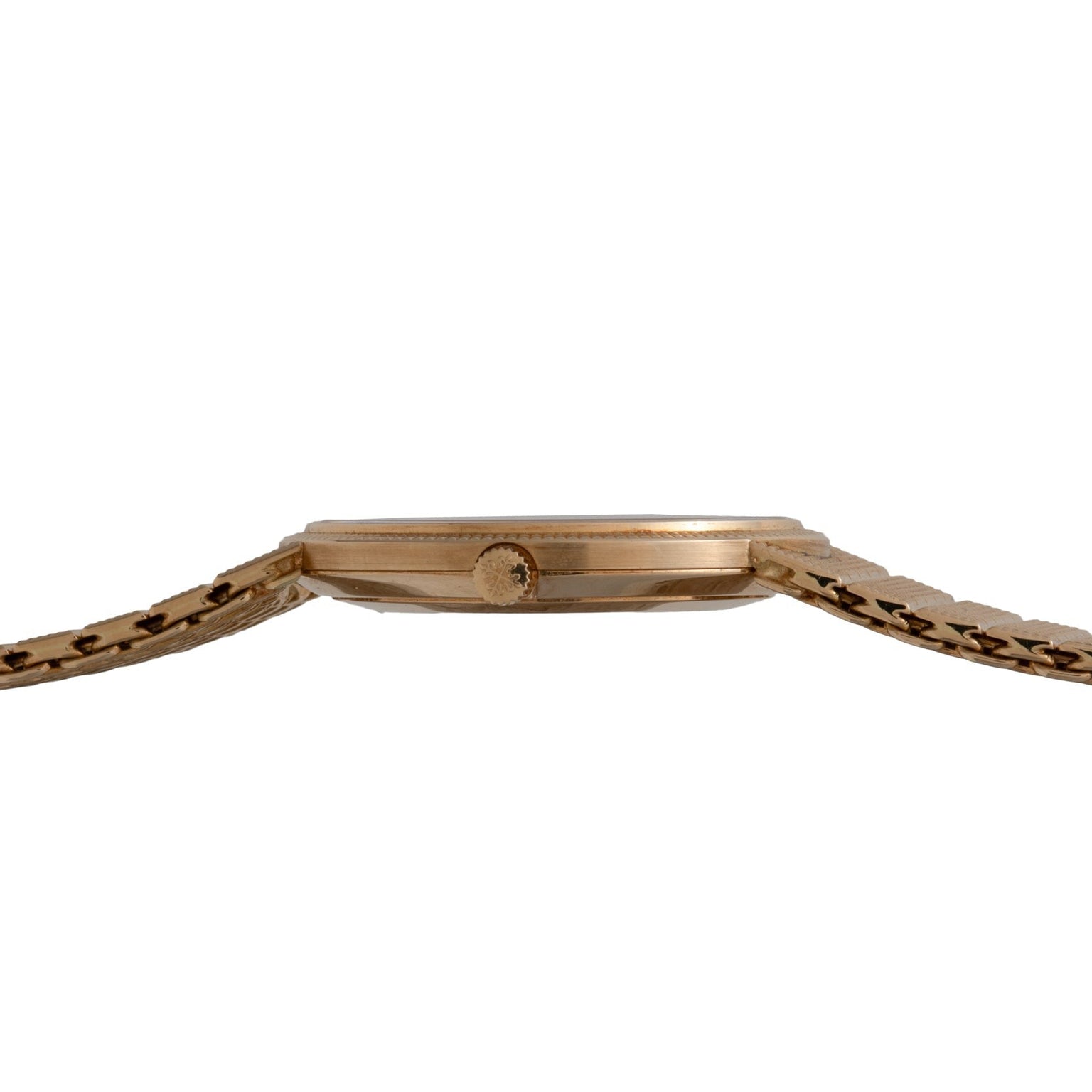 Side view of the Patek Philippe Calatrava, a slim gold wristwatch featuring a textured bracelet and a round crown.