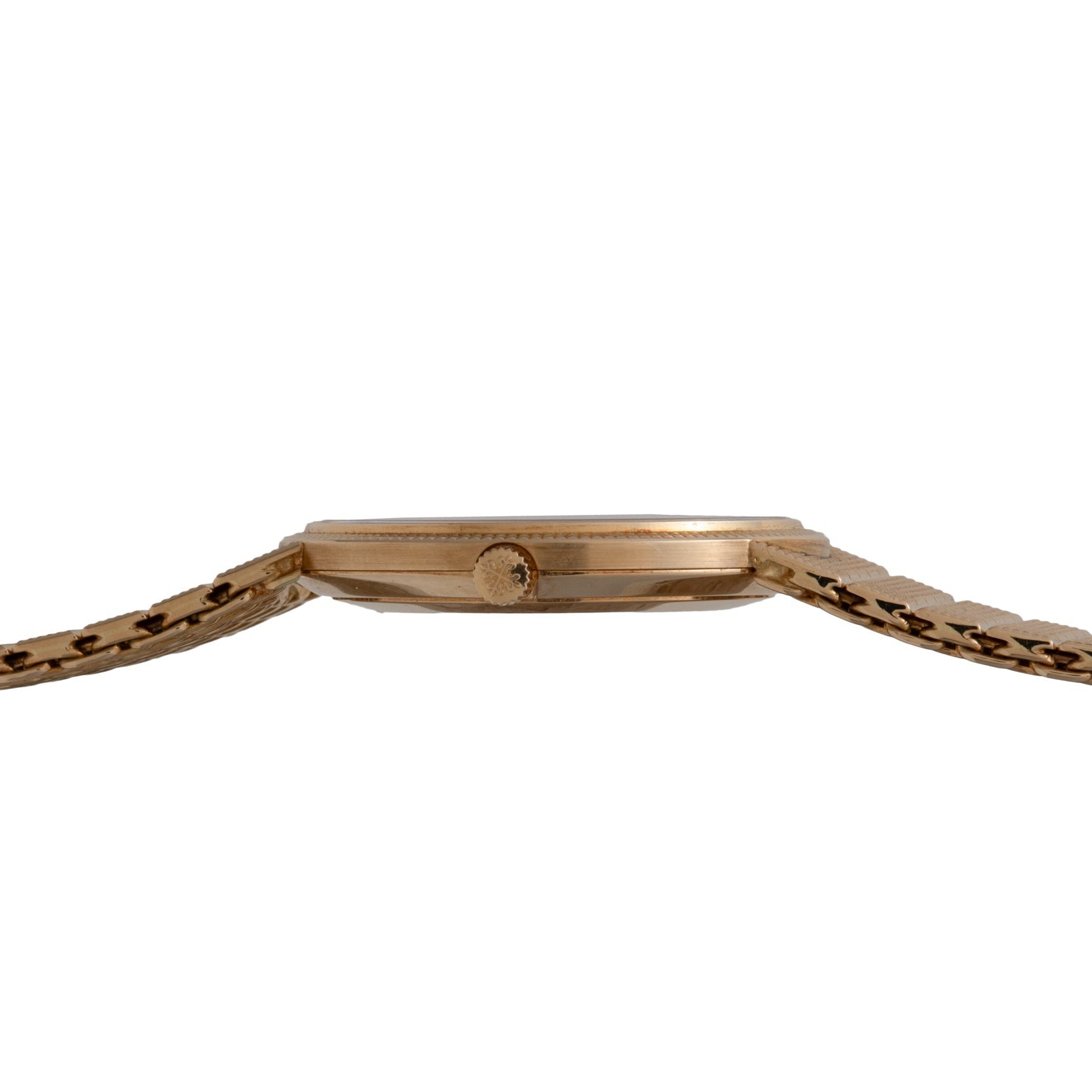 Side view of the Patek Philippe Calatrava, a slim gold wristwatch featuring a textured bracelet and a round crown.