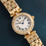 Cartier Panthere Ronde watch with diamond bezel and Roman numeral dial displayed on a dark textured surface.