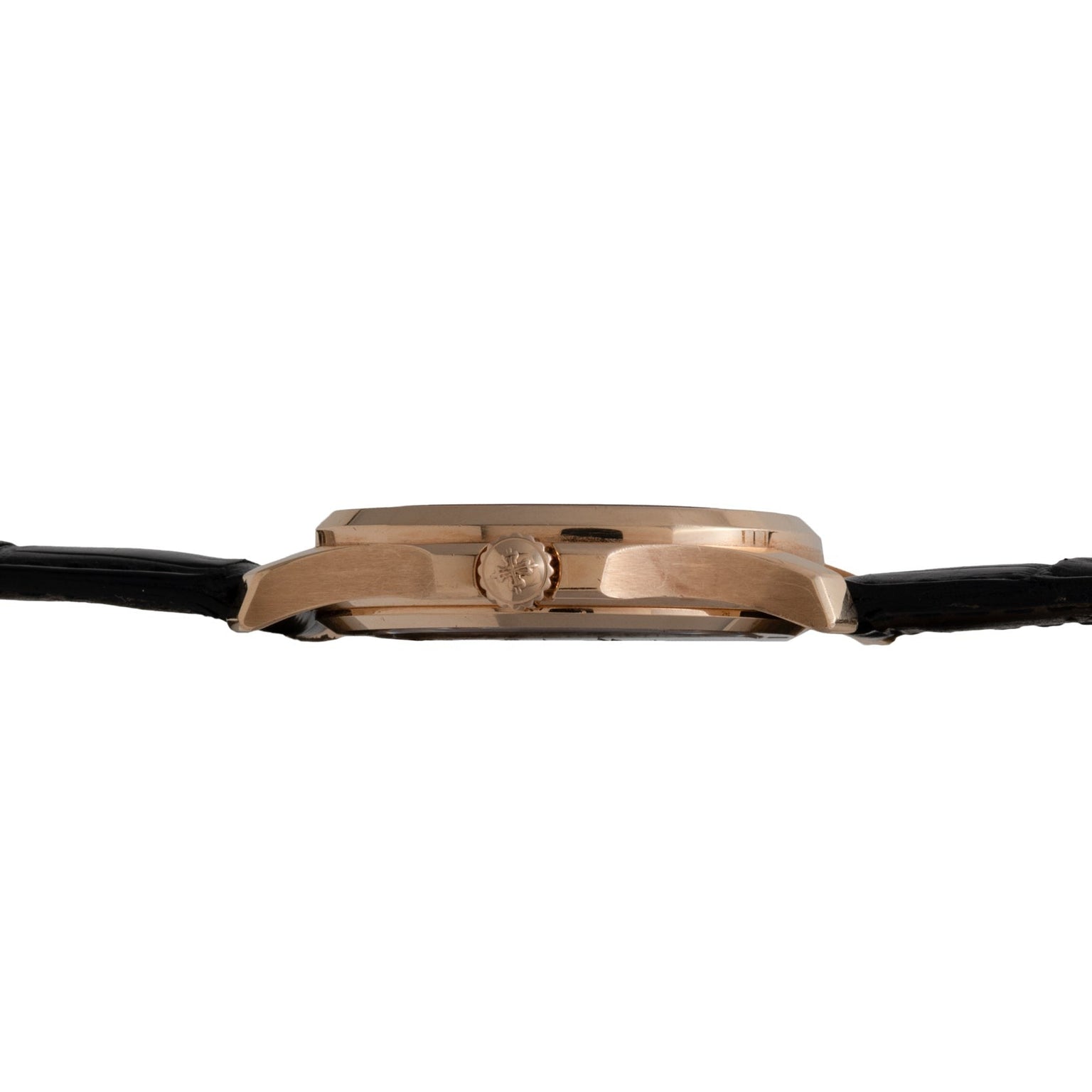 Side view of the Patek Philippe Aquanaut gold wristwatch featuring a black leather strap and a round crown.