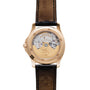 Back view of the Patek Philippe Aquanaut showcasing its gold movement and black leather strap.