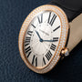 Close-up of the Cartier Baignoire Jumbo watch featuring a diamond bezel, black Roman numerals, and a black leather strap.