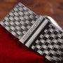 Close-up of a Patek Philippe Gondolo Ladies silver watch bracelet resting on red fabric.