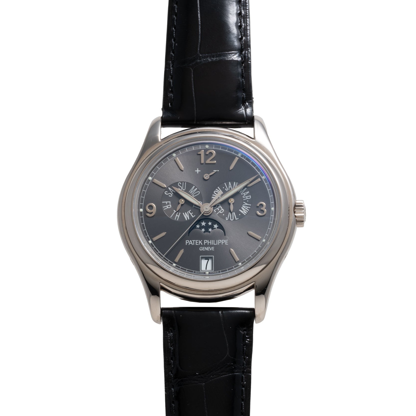 A Patek Philippe Annual Calendar Moonphase wristwatch featuring a black leather strap and a black dial with multiple subdials.