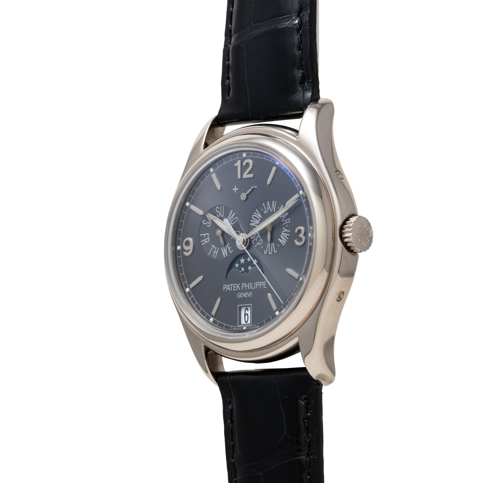 Patek Philippe Annual Calendar Moonphase wristwatch in silver with a black leather strap and dark dial featuring day, date, and moonphase indicators.