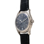 Patek Philippe Annual Calendar Moonphase wristwatch in silver with a black leather strap and dark dial featuring day, date, and moonphase indicators.