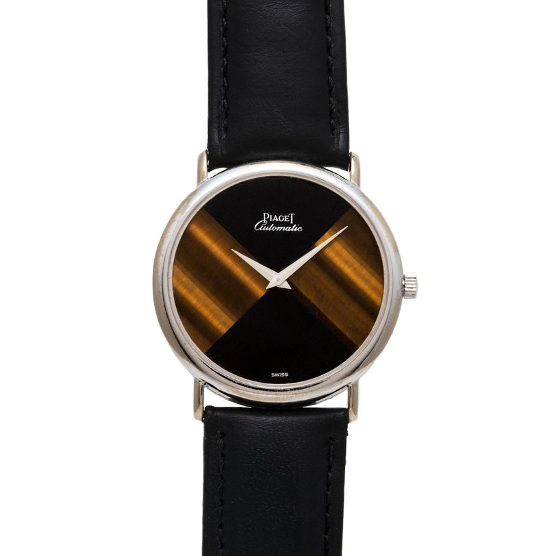 Piaget Tigers Eye Onyx Dress Watch featuring a black and gold striped dial, silver case, and black leather strap.