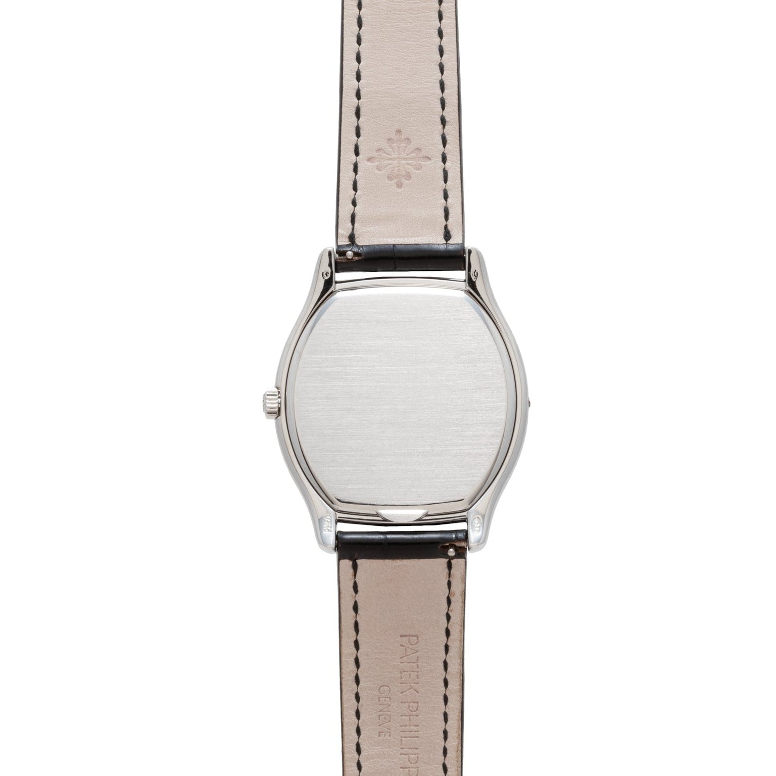 Back view of the Patek Philippe Tonneau Perpetual Calendar wristwatch with a plain silver case and beige leather strap featuring stitched edges.