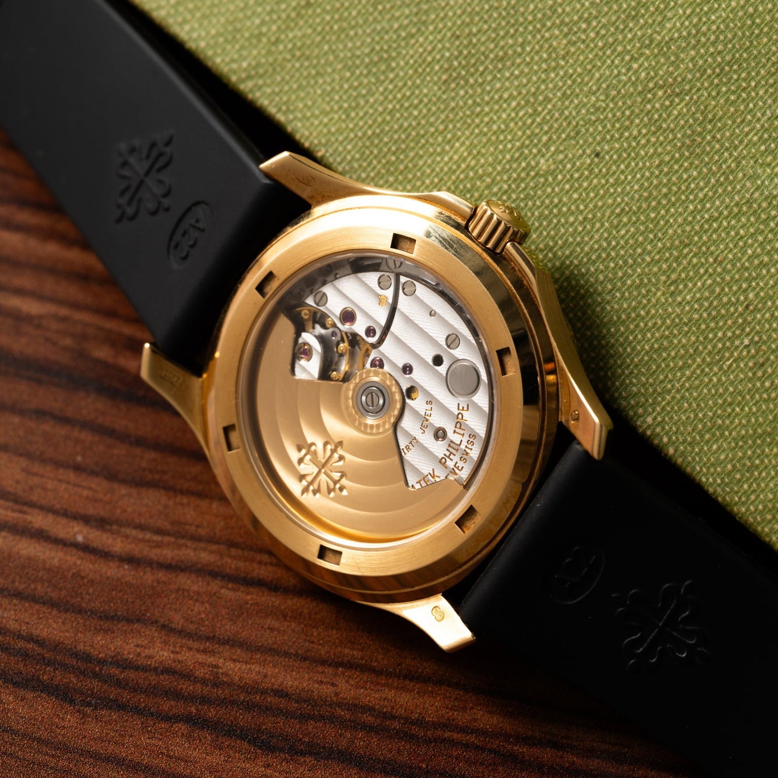 Close-up of the Patek Philippe Aquanauts transparent case back, revealing its intricate mechanical movement and black strap.