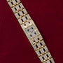 Piaget Polo Pave diamond-encrusted gold wristwatch displayed on a red textured background.