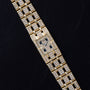 The Piaget Polo Pave, a gold wristwatch with a rectangular face and diamond accents, is showcased on a black leather surface.
