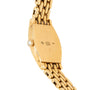 Back of a gold Cartier Tortue Diamond watch with hallmark engravings, pearl crown, and gold link bracelet.