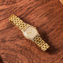 The Cartier Tortue Diamond wristwatch, featuring diamond accents, displayed on a wooden surface.