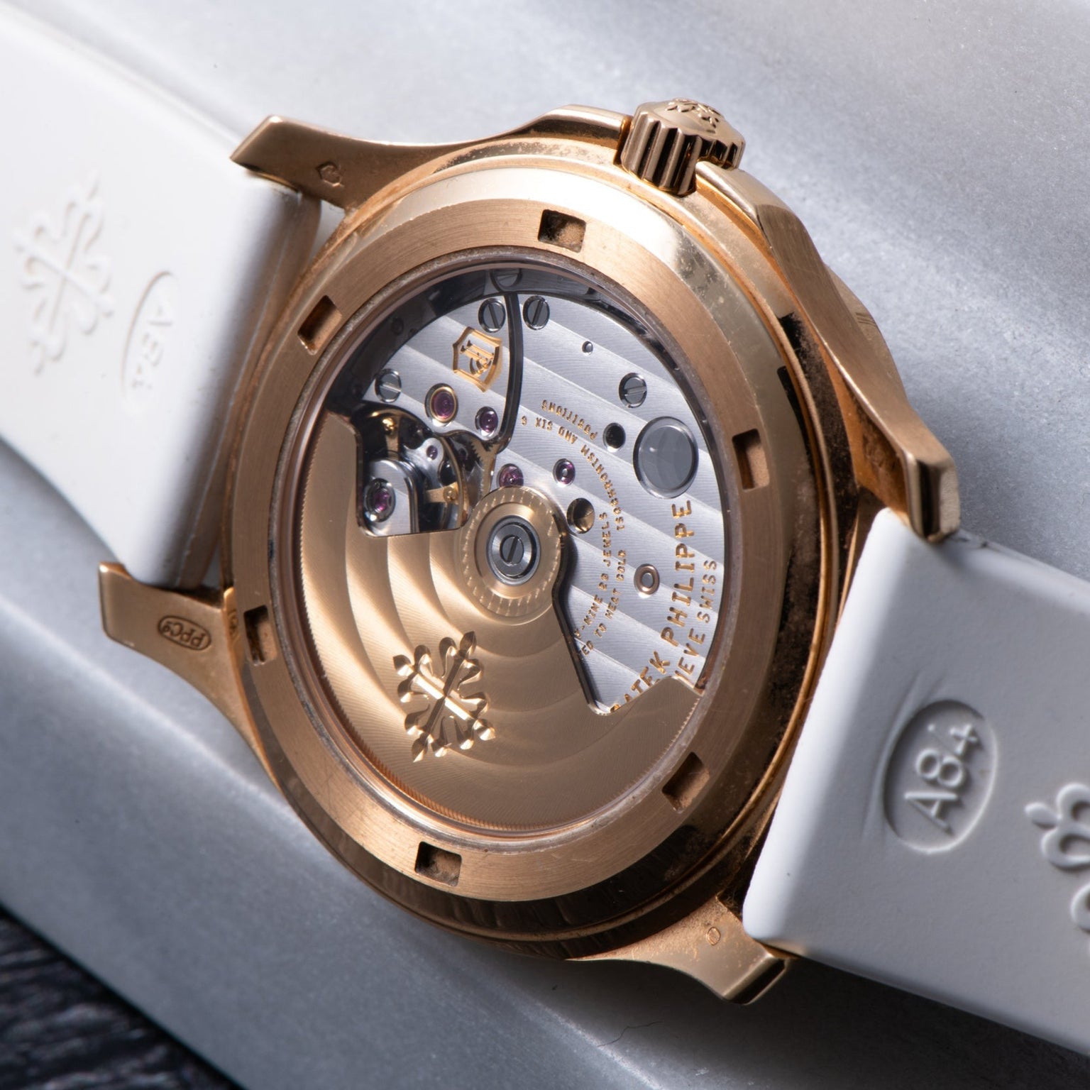 Close-up of the Patek Philippe Aquanaut Ladies watch’s open back, displaying its intricate mechanical movement and white strap.