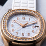 Close-up of a Patek Philippe Aquanaut Ladies watch featuring a diamond bezel and white strap, displaying the date as the 18th.
