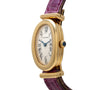 The Cartier Baignoire watch features a gold oval case, Roman numerals, blue hands, and a purple leather strap, displayed at an angle.