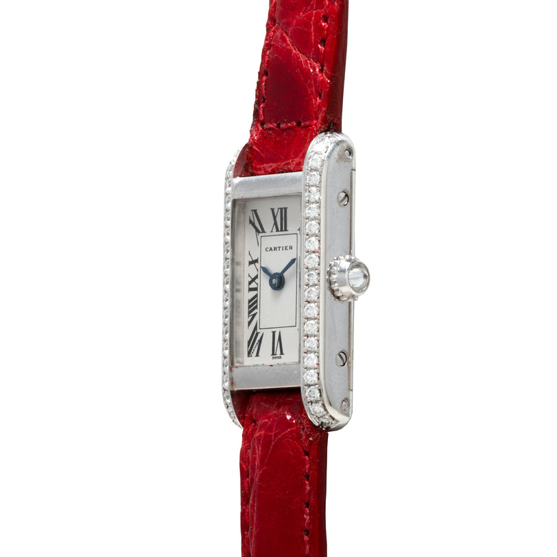 Cartier Tank Louis Mini with diamond bezel, silver dial, Roman numerals, and red leather strap.
