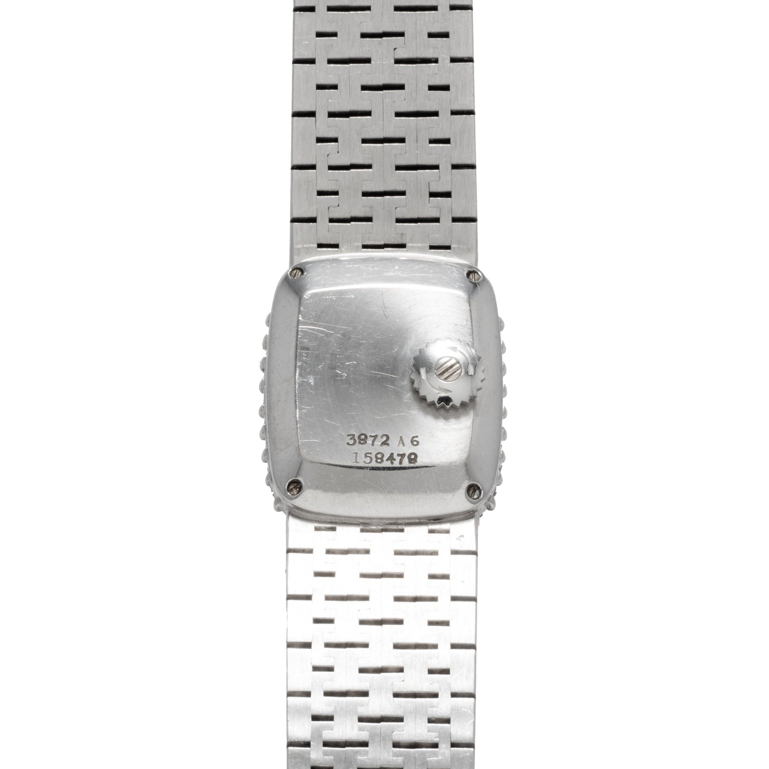 Back view of a Piaget White Gold Bark Diamond Dress Watch featuring a metal strap and engraved serial numbers on the case.