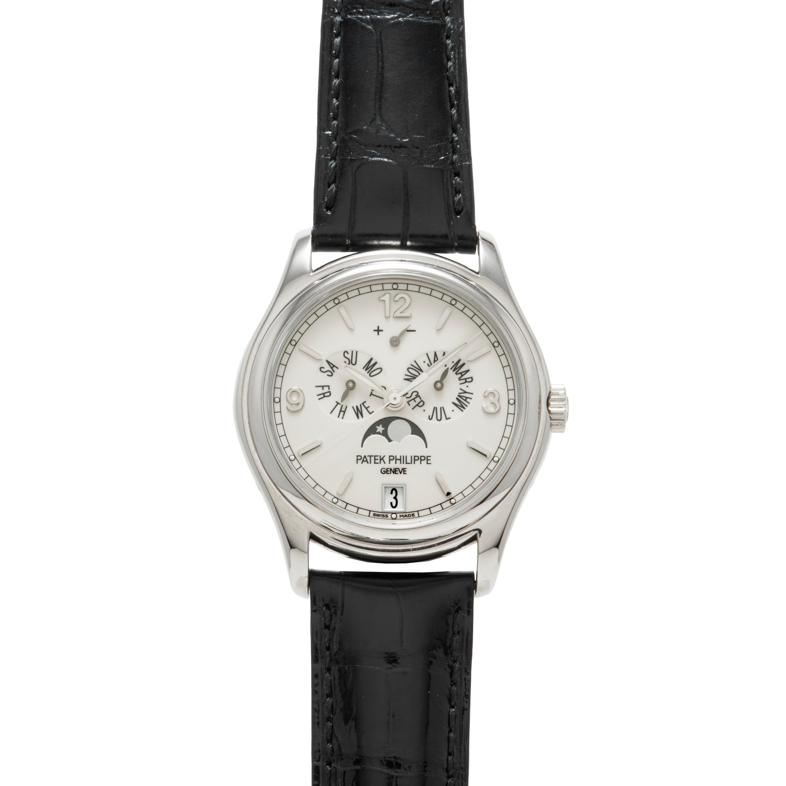The Patek Philippe Annual Calendar Moonphase features a white dial with Arabic numerals, black hour and minute hands, moon phase display, annual calendar, date window at 6 o'clock, white gold case, and a black leather strap.