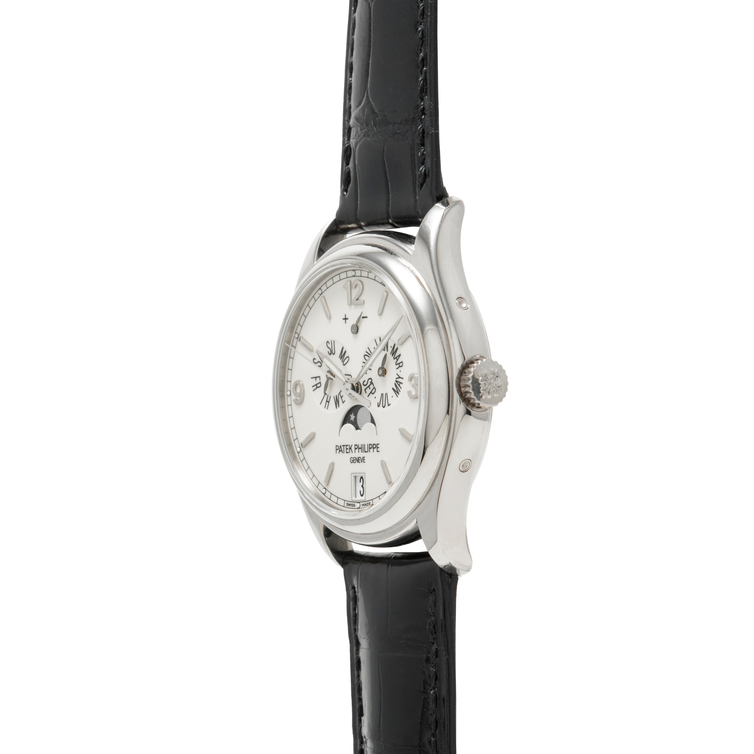 A Patek Philippe Annual Calendar Moonphase wristwatch, featuring a white gold case, white dial, black leather strap, and visible side view showing the crown along with annual calendar and moon phase indicators.