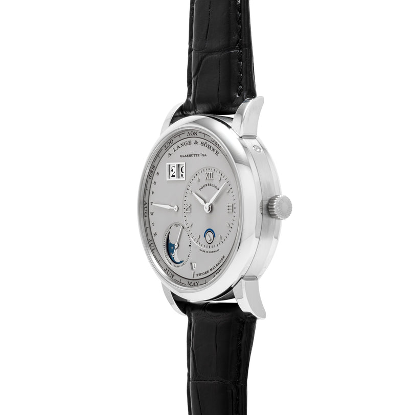Lange & Sohne Lange 1 Tourbillon Perpetual Calendar, a silver luxury wristwatch with black leather strap, multiple dials, and moonphase display shown from an angled side view.