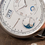 Close-up of the Lange & Sohne Lange 1 Tourbillon Perpetual Calendar, showcasing its silver dial with date, month, day, and moon phase displays.
