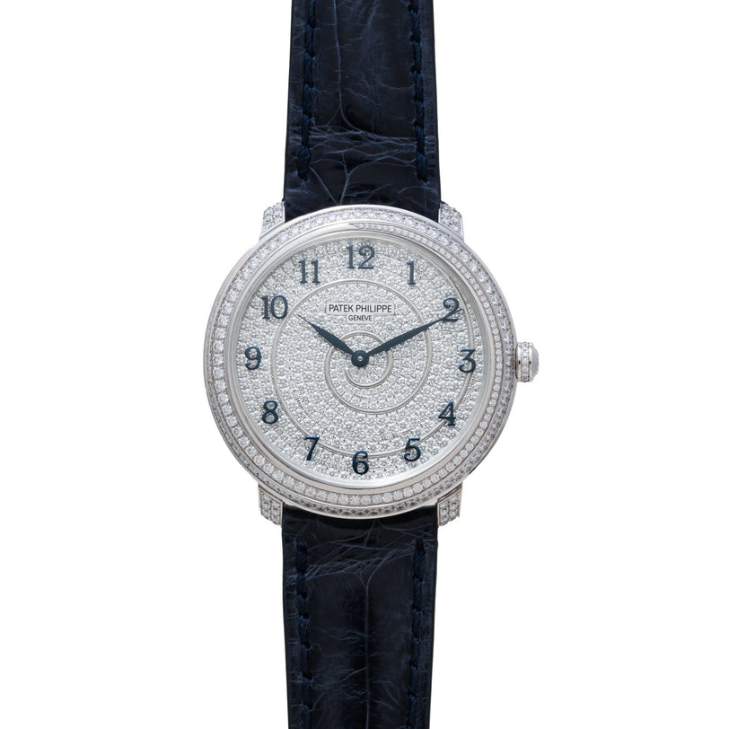A Patek Philippe Calatrava wristwatch featuring a diamond-encrusted case, black leather strap, and silver dial.