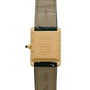 Back view of the Cartier Tank Louis watch, featuring a gold case, green leather strap, and engraved markings.