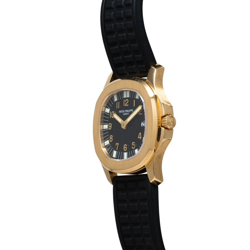 The Patek Philippe Aquanaut wristwatch features a black face and rubber strap, captured at an angle against a white background.