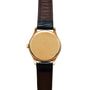 The Patek Philippe Calatrava wristwatch is shown face down, revealing its scratched gold back and the black and brown leather strap.