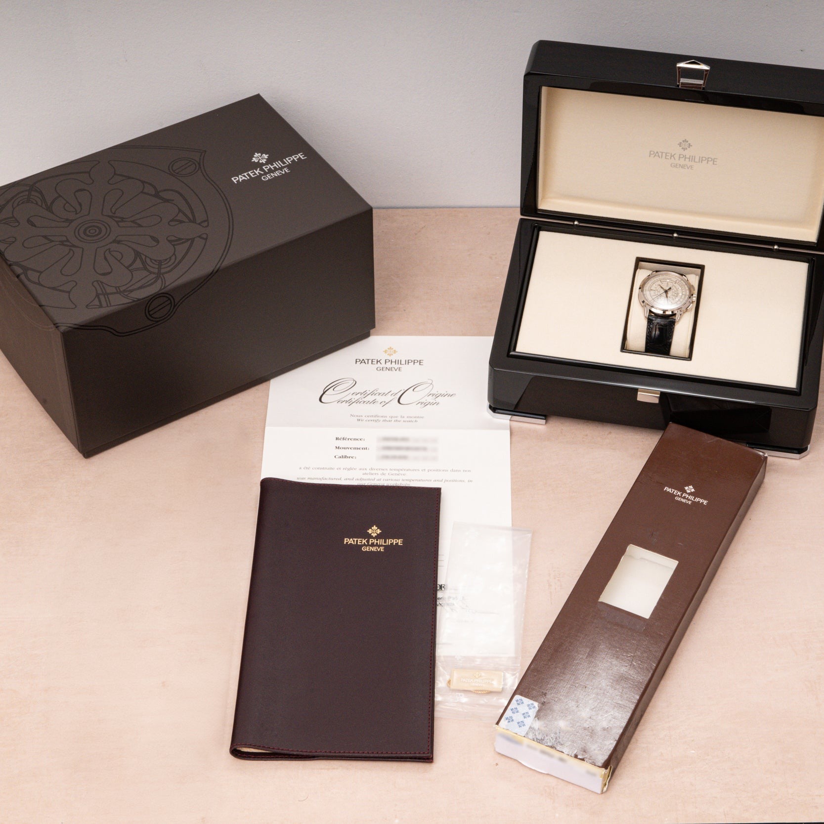 Patek Philippe Multi-Scale Chronograph with box, certificate, booklet, and accessories displayed on a light-colored surface.