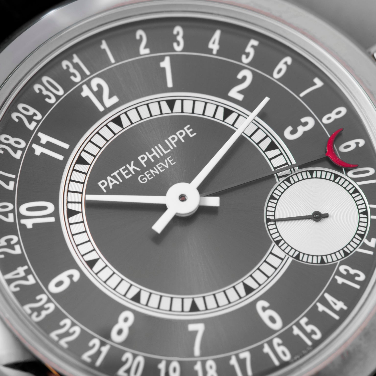 Close-up of a Patek Philippe Calatrava watch face featuring date numbers, hands, and a small seconds subdial.