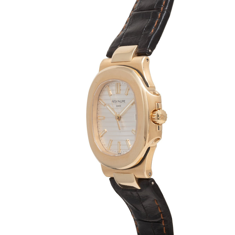 A Patek Philippe Nautilus wristwatch with a black leather strap, shown from a side angle.