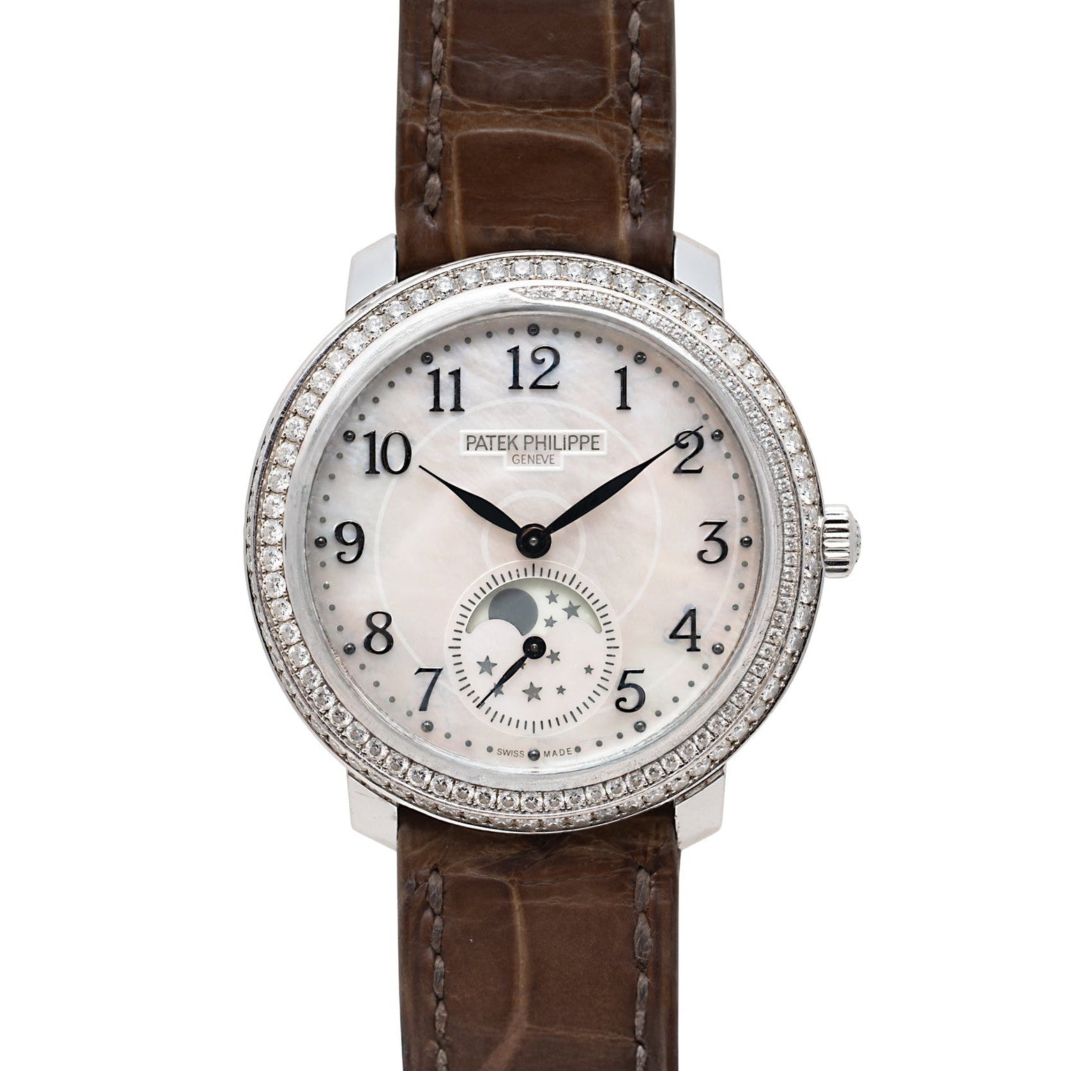 A Patek Philippe Ladies Complication watch featuring a diamond bezel, white dial, moonphase, and brown leather strap.