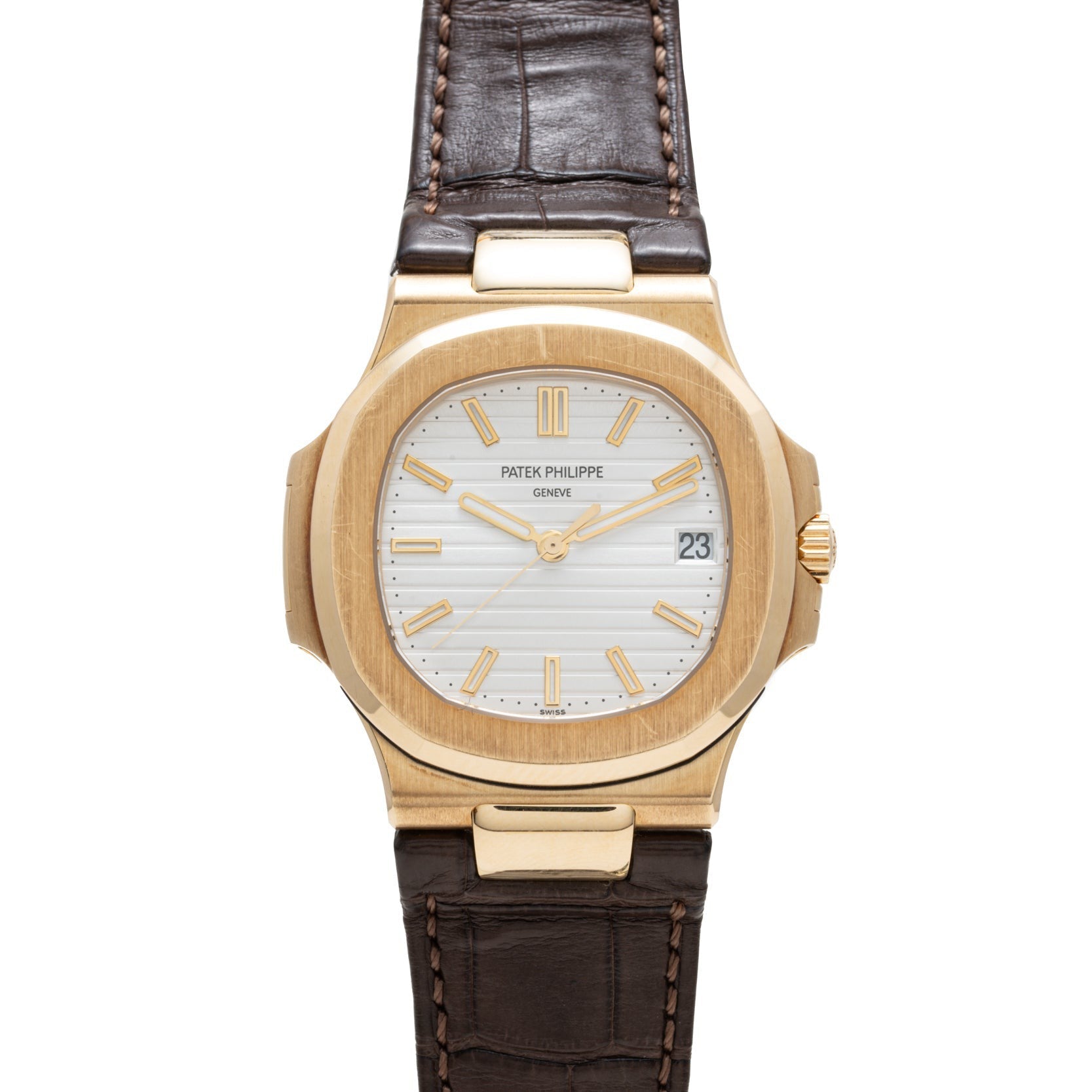 Patek Philippe Nautilus gold wristwatch with white dial, gold hour markers, brown leather strap, and date display at 3 oclock.