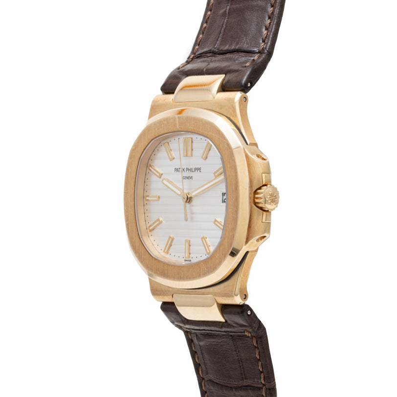 A Patek Philippe Nautilus wristwatch with a white dial and brown leather strap, displayed at an angle.
