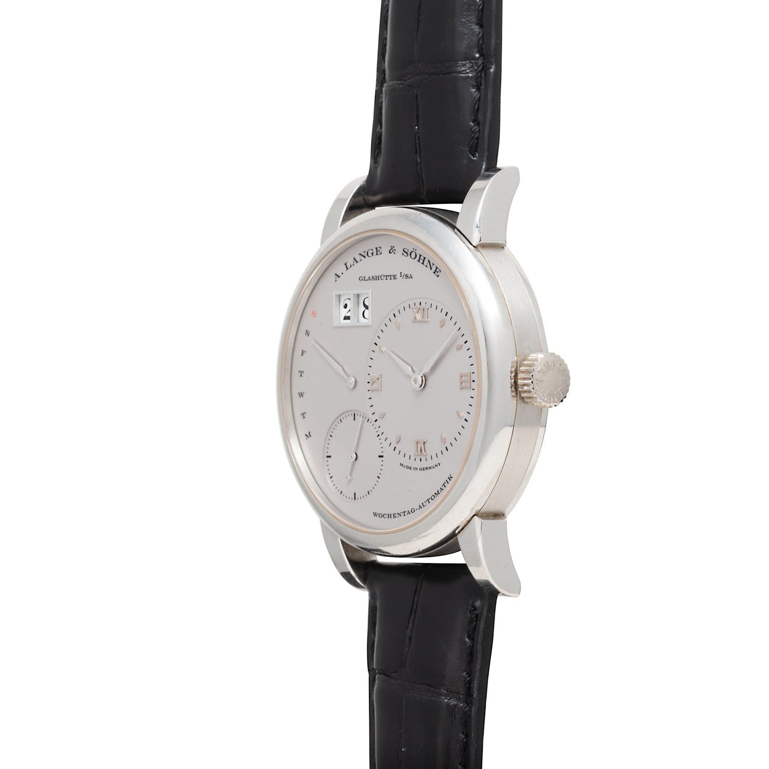 The Lange & Sohne Lange 1 Daymatic is a luxury silver wristwatch with a black leather strap and multiple dials on a white background.