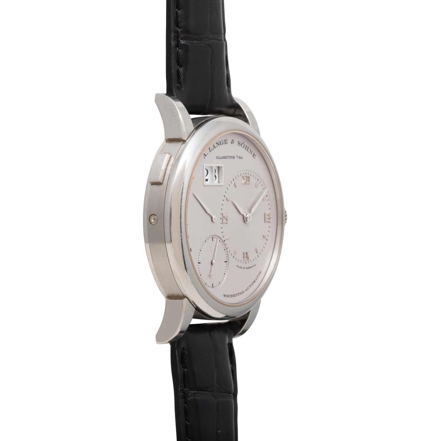 Lange & Sohne Lange 1 Daymatic watch with black leather strap, white dial, and subdials, shown from a side angle.