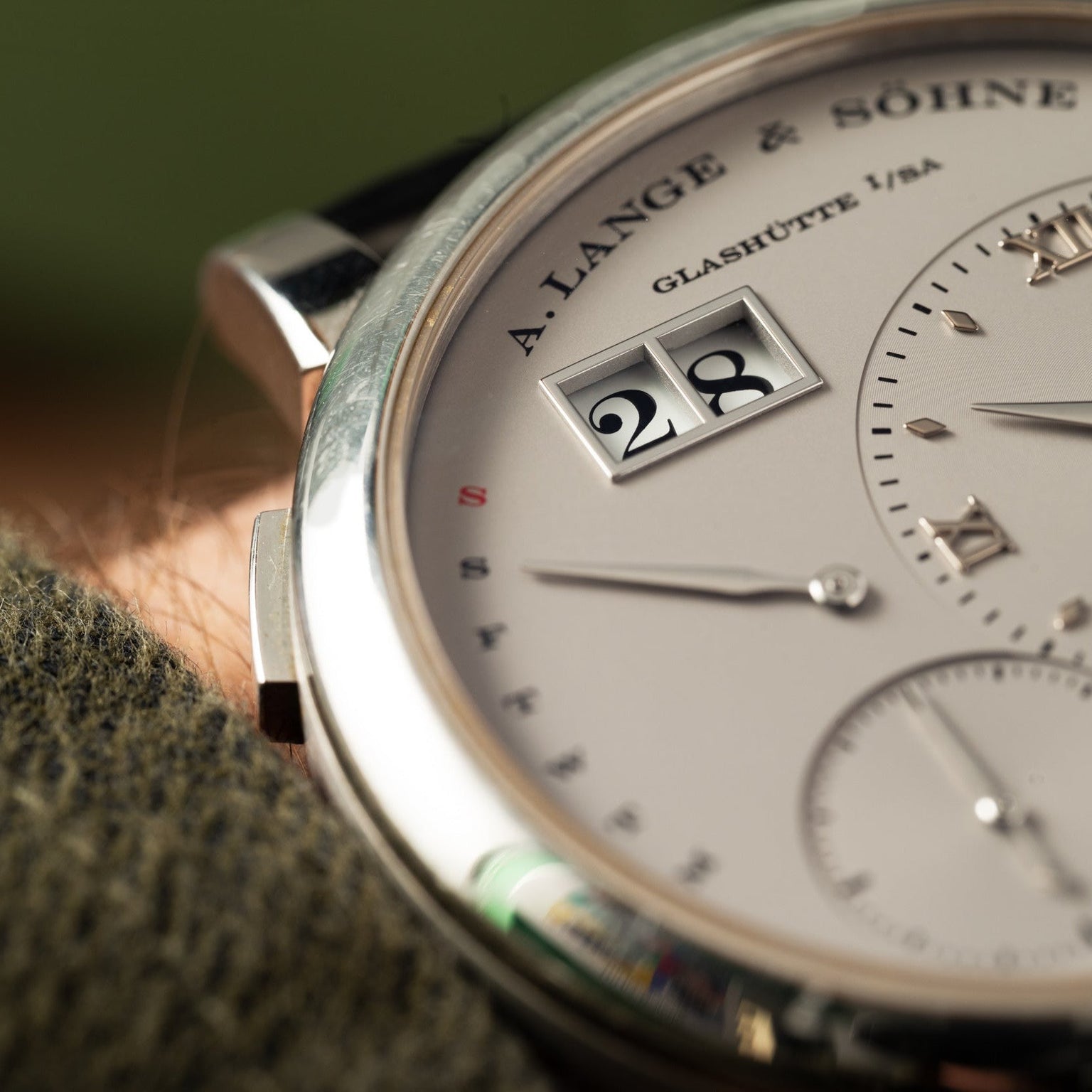 Close-up of the Lange & Sohne Lange 1 Daymatic watch, showing its detailed dial, hands, and visible time and date display.