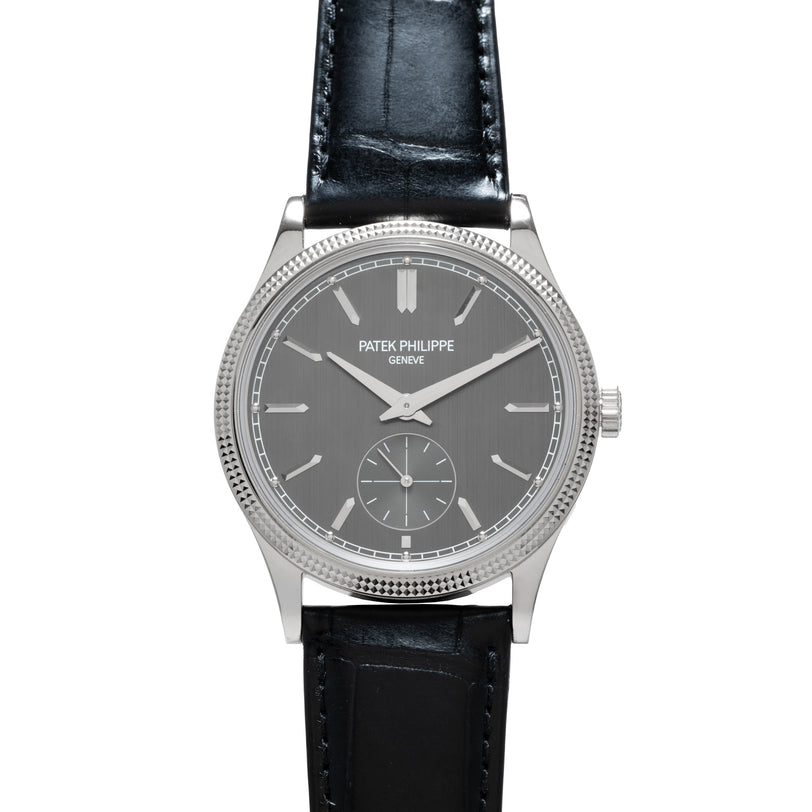 A Patek Philippe Calatrava wristwatch featuring a silver case, gray dial, and black leather strap.