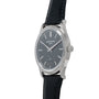 A Patek Philippe Calatrava wristwatch in silver with a black leather strap and dark dial, displayed at an angle.
