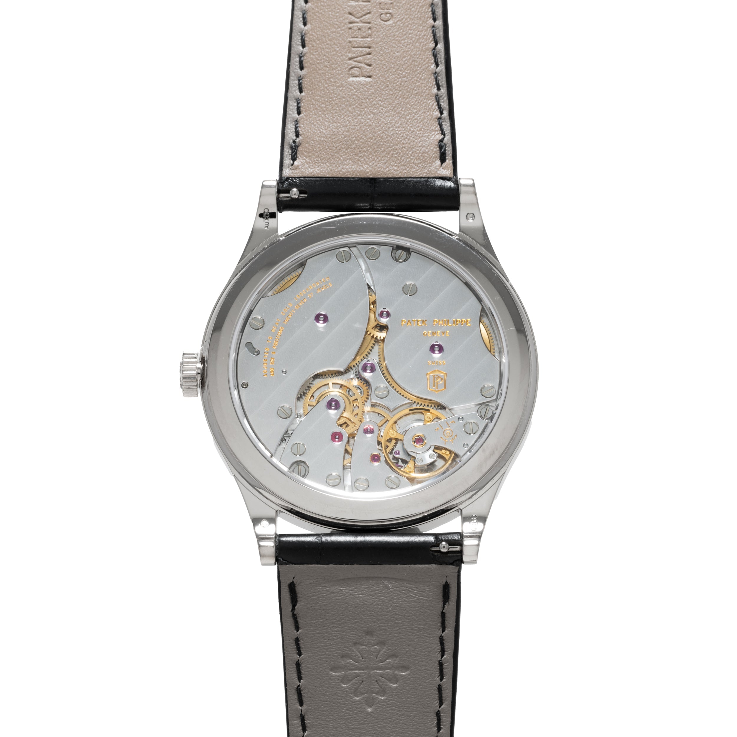The Patek Philippe Calatrava is a luxury wristwatch featuring a leather strap and a transparent case back that reveals its intricate gears and mechanisms.