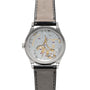 The Patek Philippe Calatrava is a luxury wristwatch featuring a leather strap and a transparent case back that reveals its intricate gears and mechanisms.