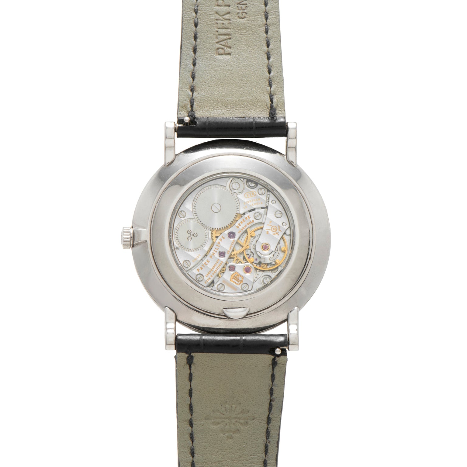 Back view of the Patek Philippe Calatrava showcasing its exposed intricate mechanical movement and black leather strap.