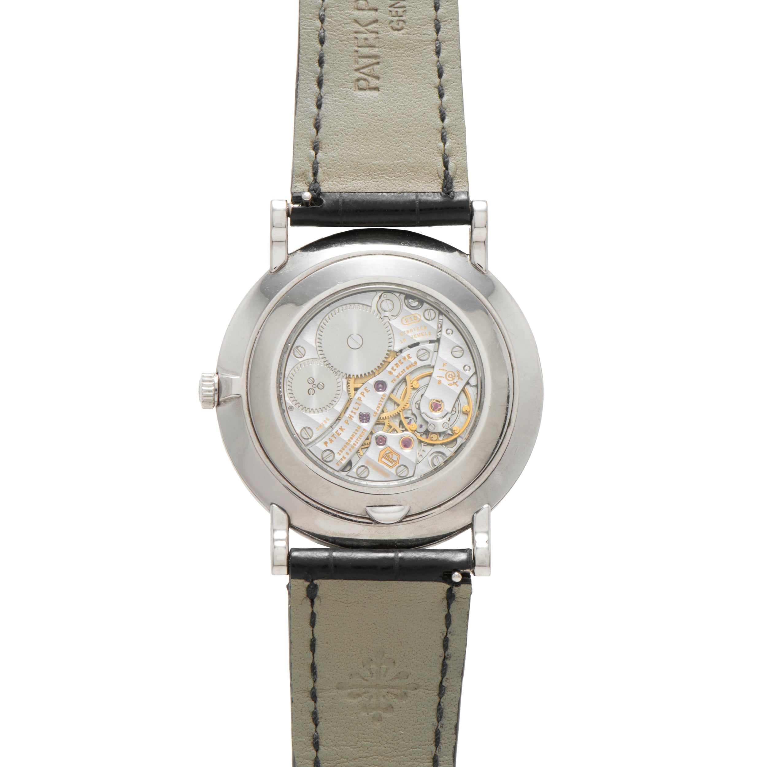 Back view of the Patek Philippe Calatrava showcasing its exposed intricate mechanical movement and black leather strap.