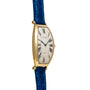 Cartier Tonneau XL wristwatch with Roman numerals and a blue leather strap, displayed from a side angle.