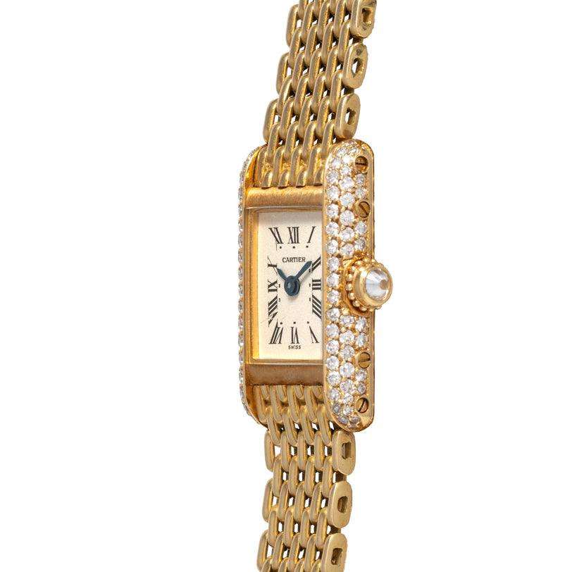 The Cartier Tank Louis Mini Diamonds is a gold wristwatch featuring a rectangular face, Roman numerals, and diamond accents on the sides.