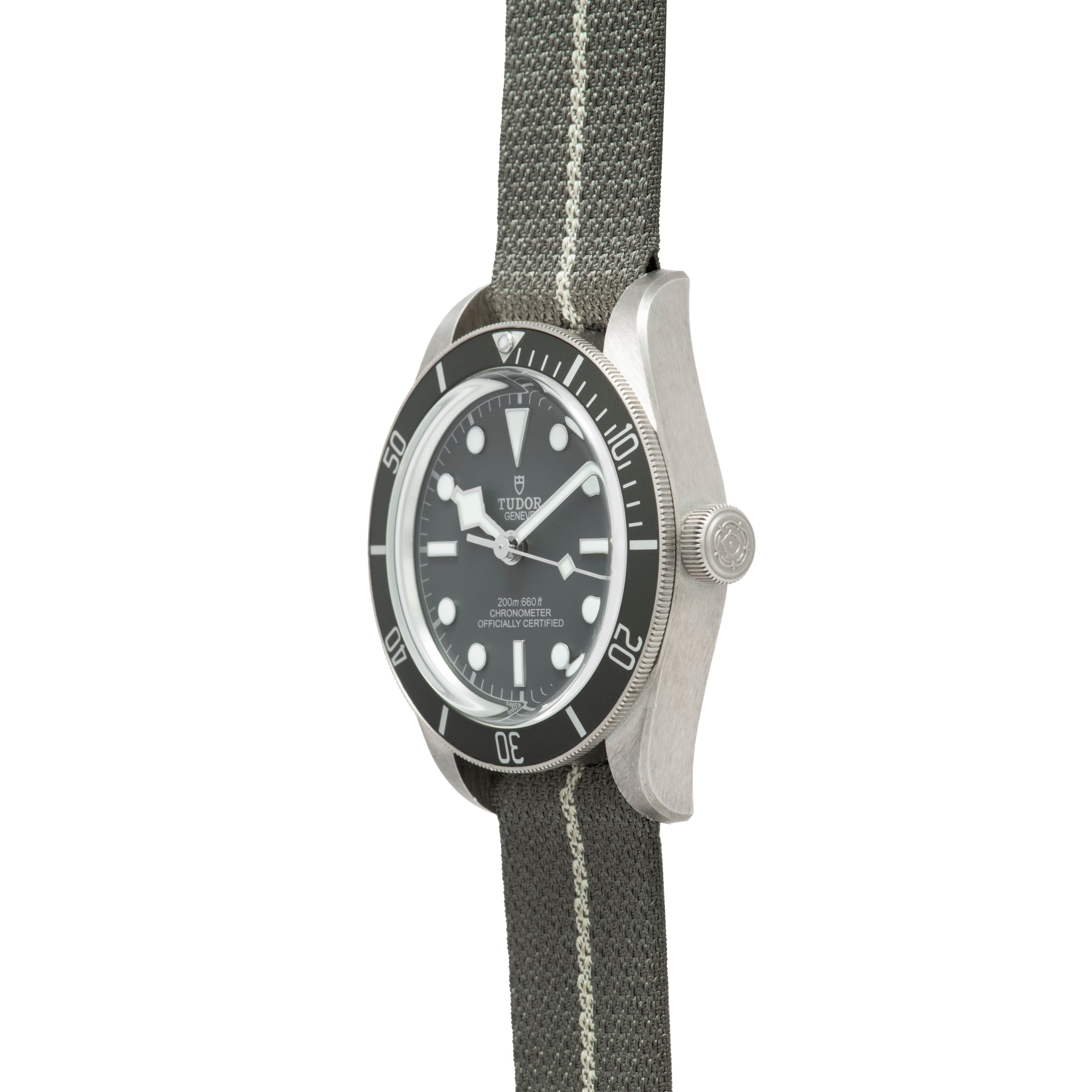 The TUDOR Black Bay 58 Silver is a dive watch with a black bezel and dial, paired with a gray fabric strap featuring a white center stripe.