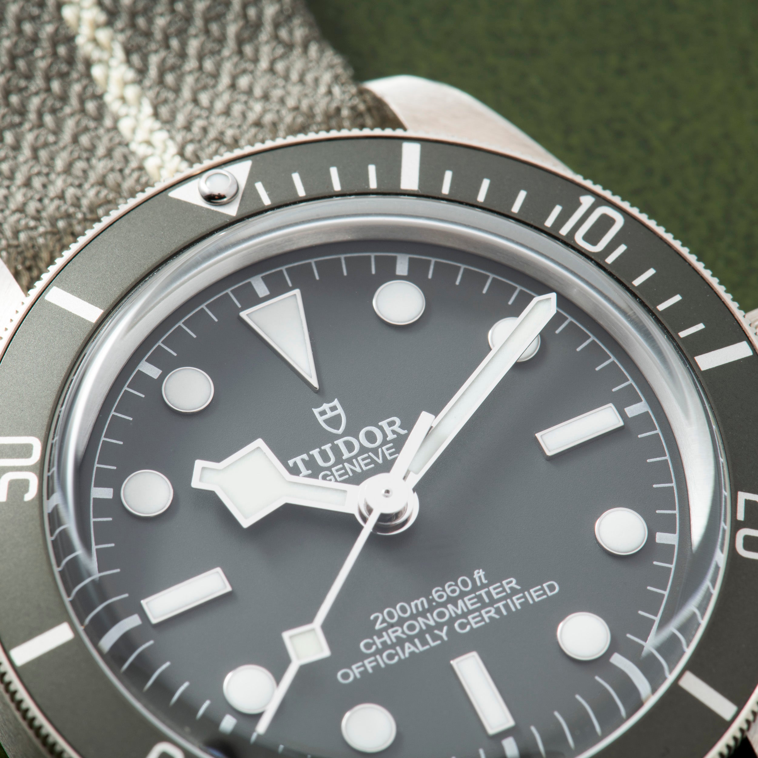 Close-up of the TUDOR Black Bay 58 Silver dive watch, featuring a grey dial, white markers, and a fabric strap.
